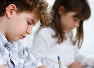 Close up of a boy and a girl writing something while studying