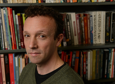 Color portrait of Luis van Isschot with a bookcase background